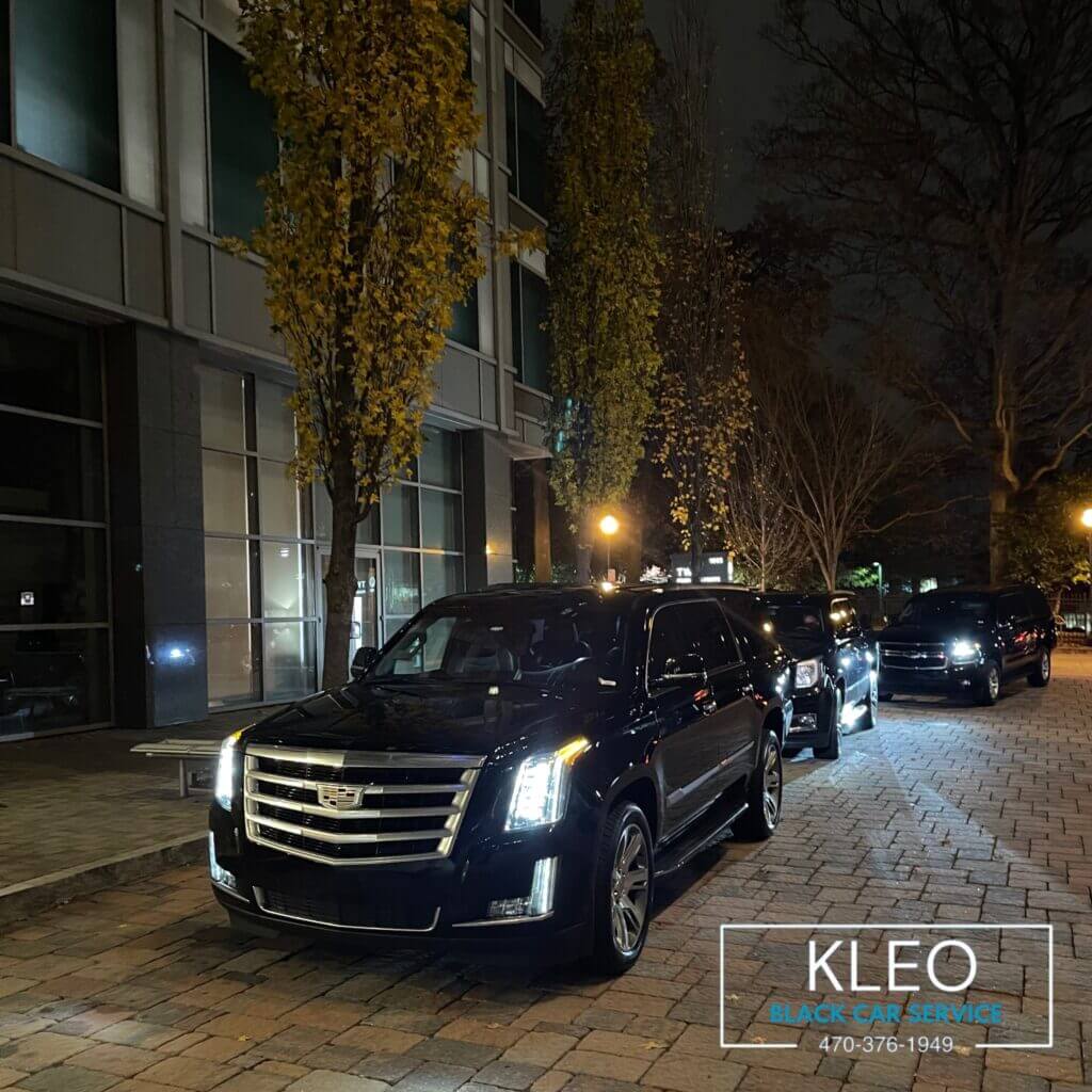 Luxury Cadillac SUV fleet at night – Suwanee limo service for executive and airport transportation