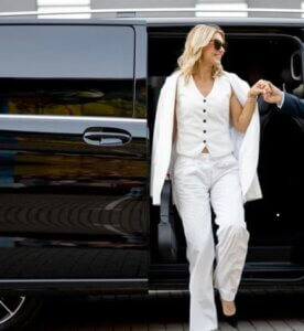 Chauffeur assisting woman stepping out of luxury black car in Atlanta – Kleo Black Car Service.